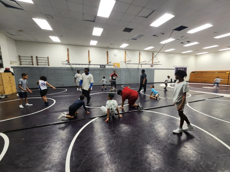 Coach teaching wrestling to young students 