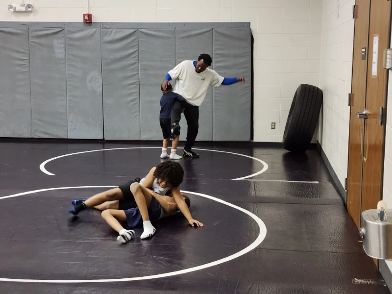 a group of people wrestling on a wrestling mat